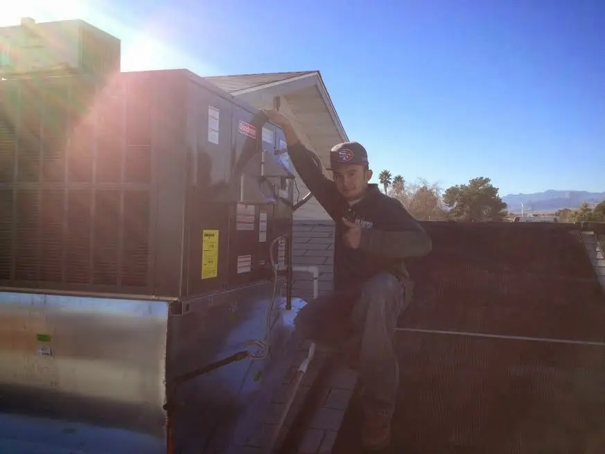 HVAC technician performing AC Tune-Up on a rooftop unit in Poway